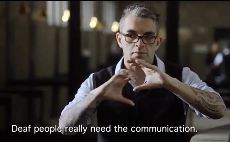 Jared Flitcroft signing. The caption at the bottom of the screenshot reads "Deaf people really need the communication."